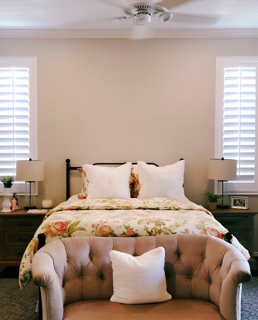white plantation shutters flanking a bed in a master bedroom